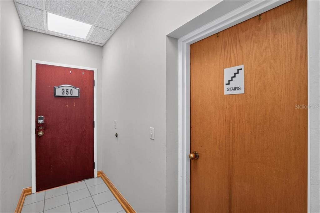 A hallway features a red door labeled 350 and a wooden door marked with stairs — 100 2ND AVENUE N UNIT 350, ST PETERSBURG, FL