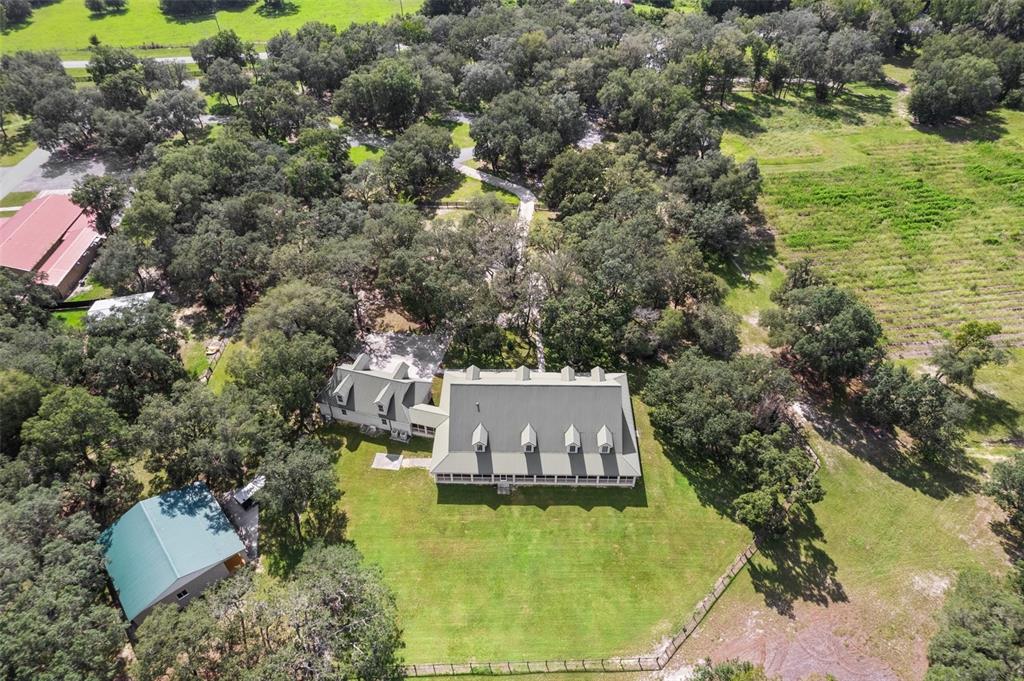 An aerial view shows a large house with a green roof surrounded by trees — 8123 S LECANTO HIGHWAY, LECANTO, FL