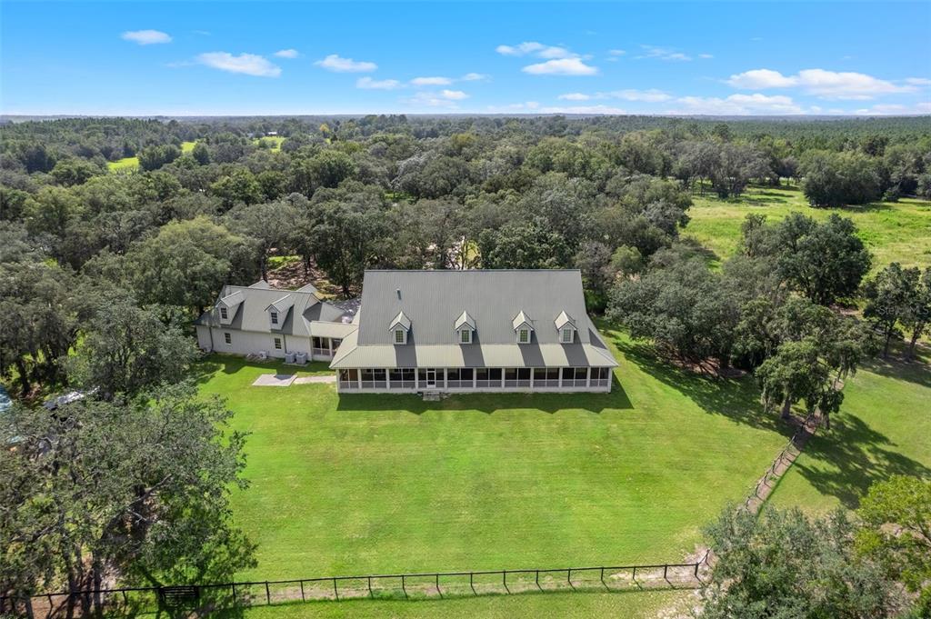 An aerial view shows a large house with a metal roof and screened porch — 8123 S LECANTO HIGHWAY, LECANTO, FL