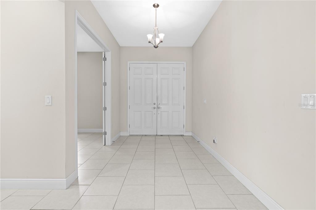 A tiled entryway features a white double door, a light fixture, and a side doorway — 13830 MOONSTONE CANYON DRIVE, RIVERVIEW, FL