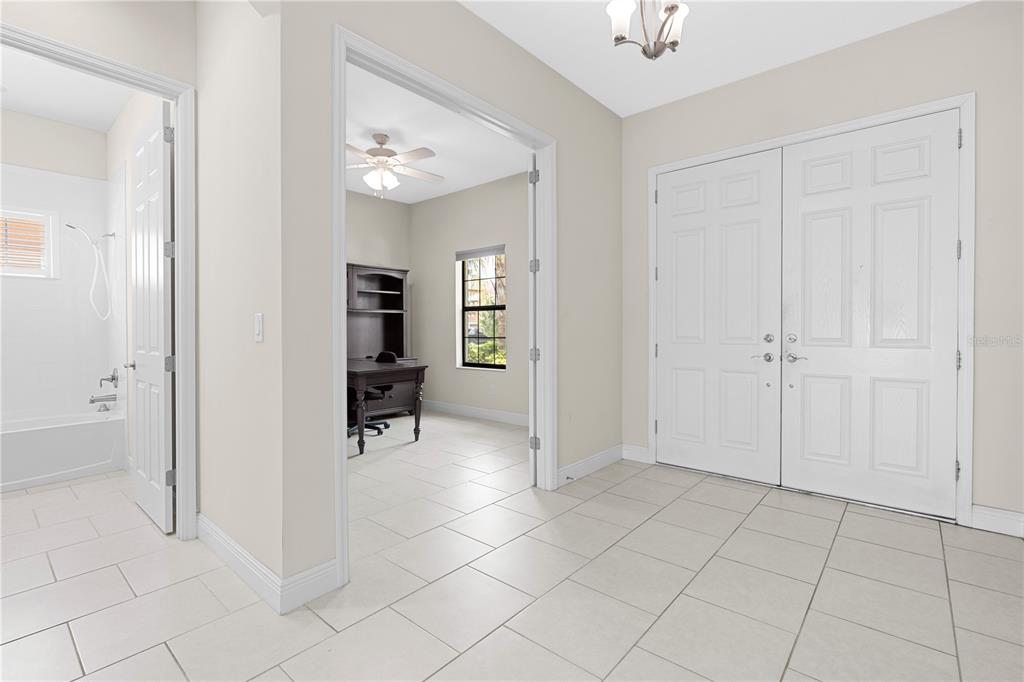 A tiled entryway features a double-door entrance, an adjacent bathroom, and a home office — 13830 MOONSTONE CANYON DRIVE, RIVERVIEW, FL