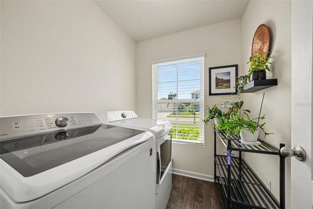 A laundry room features a white washer and dryer, a window, and a metal shelving unit — 769 GRAND RESERVE DRIVE, BUNNELL, FL