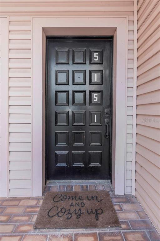 A black front door with the number 5151 sits in a light pink vinyl-sided wall — 5151 PURITAN CIRCLE UNIT 1022, TAMPA, FL