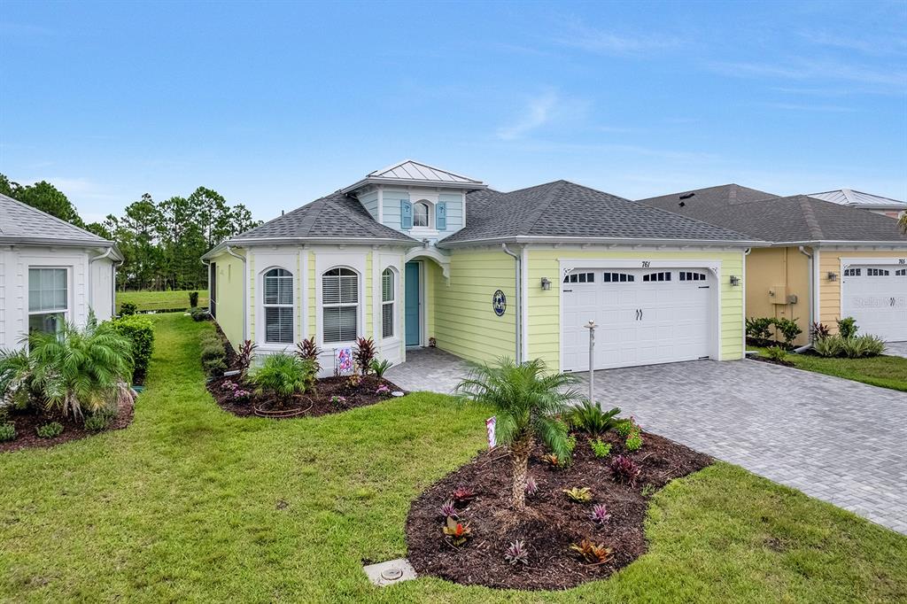 A light yellow single-story house with a gray roof and a paved driveway — 761 MARGARITAVILLE AVENUE, DAYTONA BEACH, FL