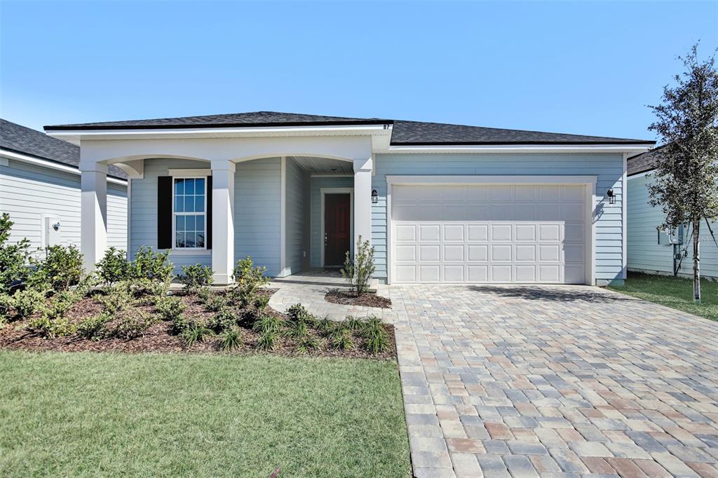 A light blue single-story house features a paved driveway, a covered porch, and a garage — 262 KNOTTED BIRCH AVENUE, ST AUGUSTINE, FL