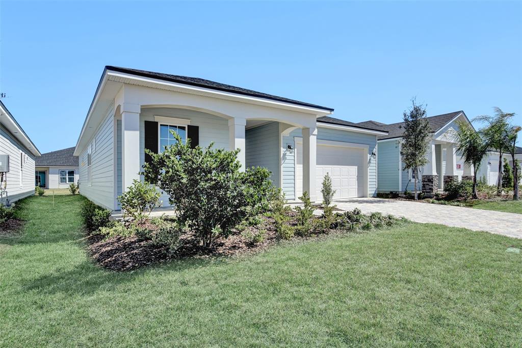 A light blue single-story house with a covered front porch and a paved driveway — 262 KNOTTED BIRCH AVENUE, ST AUGUSTINE, FL