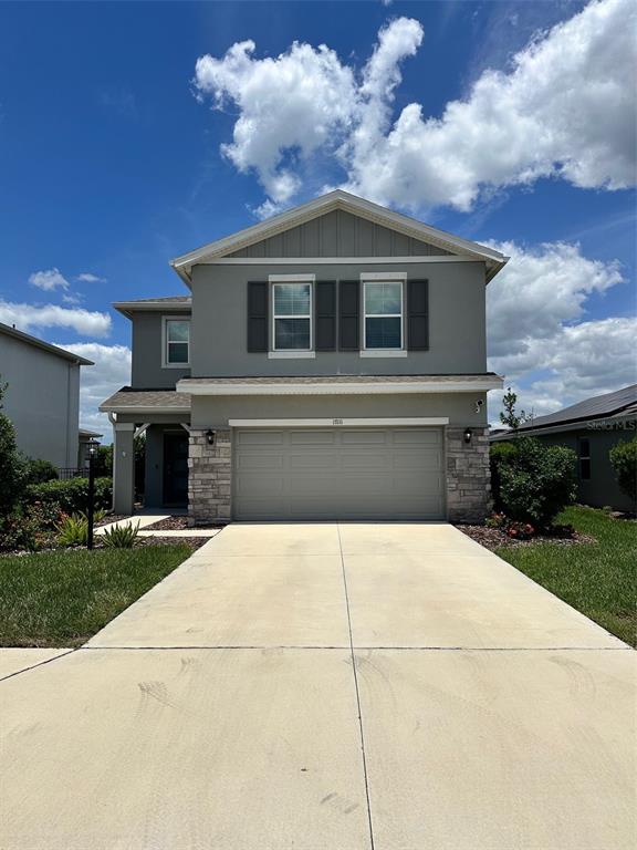 A two-story house with a gray exterior, stone accents, and a two-car garage — 17111 BARNWOOD PLACE, BRADENTON, FL