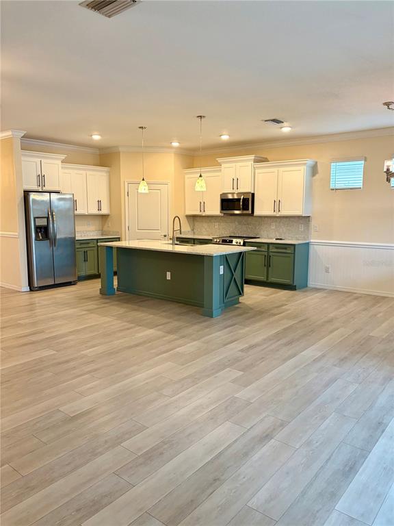 A single-story suburban house features a two-car garage, stone accents, and a large front tree — 13605 PADDINGTON WAY, SPRING HILL, FL