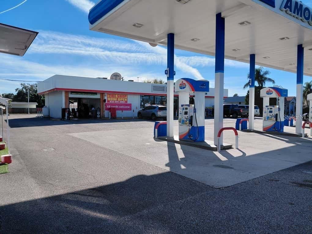 An exterior view of an Amoco gas station with a tire shop and fuel pumps — 7906 W HILLSBOROUGH AVENUE, TAMPA, FL