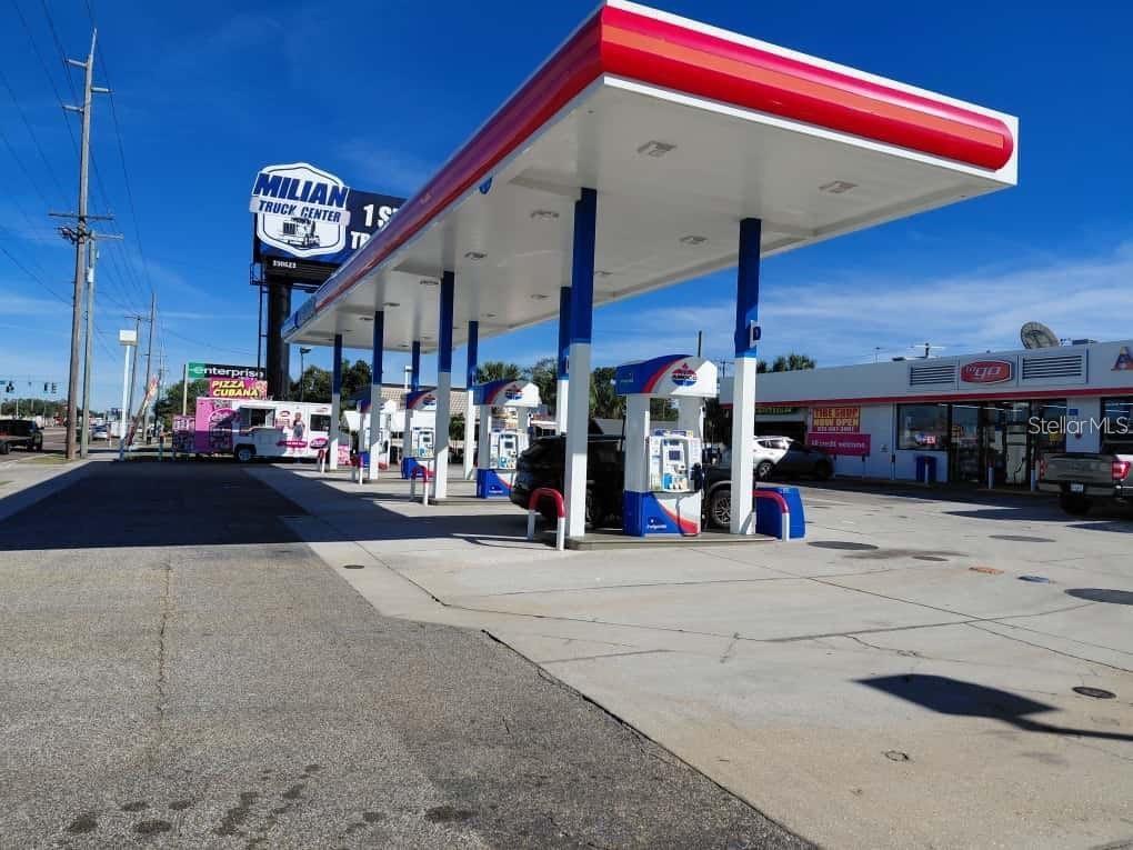 An outdoor view of a gas station with multiple fuel pumps under a large canopy — 7906 W HILLSBOROUGH AVENUE, TAMPA, FL