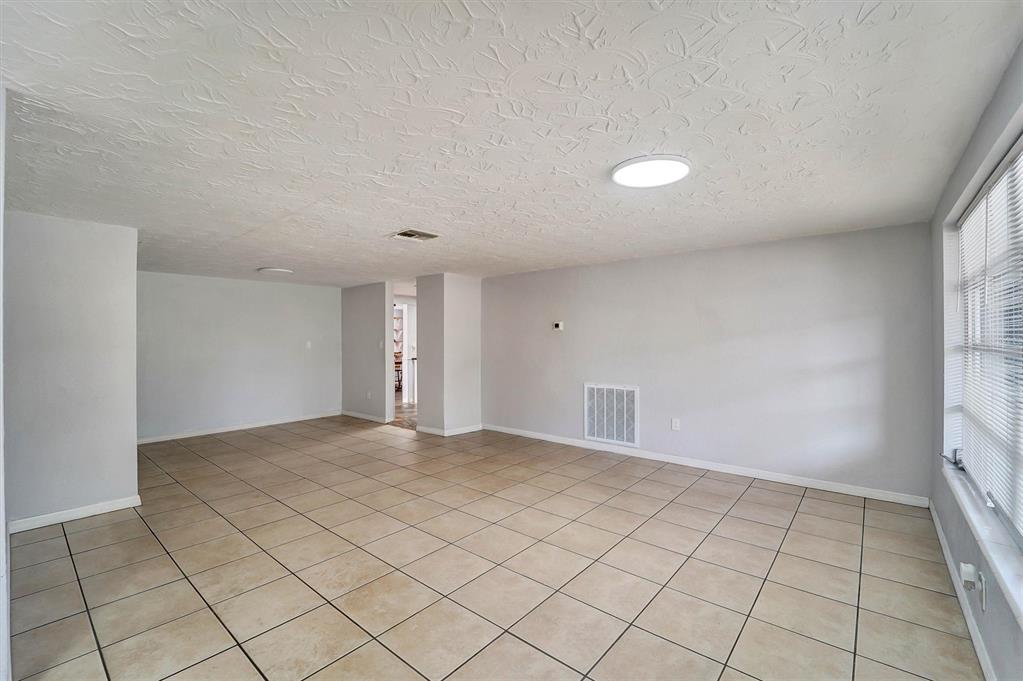 A kitchen features cream cabinets, black appliances, dark countertops, and a flagstone floor — 5344 NANCY LANE, HOLIDAY, FL