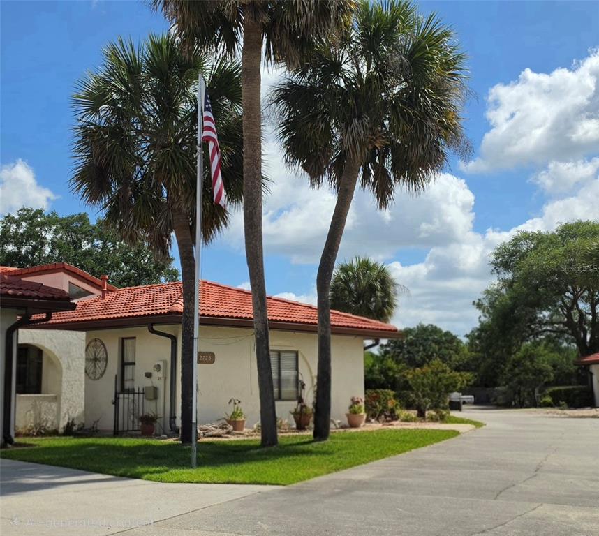 A single-story house with a red tile roof, stucco walls, and a paved driveway — 2725 CLUBHOUSE DRIVE, LAKE WALES, FL