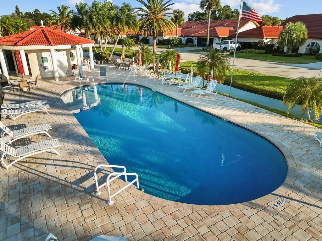 A concrete walkway leads through a metal gate toward the entrance of a stucco home — 2725 CLUBHOUSE DRIVE, LAKE WALES, FL