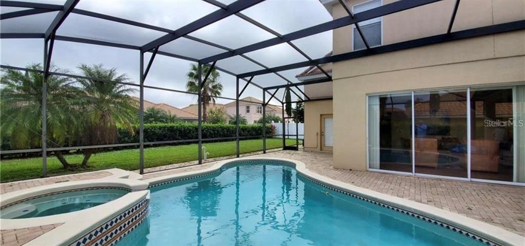 A screened-in patio features a swimming pool, a hot tub, and a paved deck area — 10914 LEDGEMENT LANE, WINDERMERE, FL