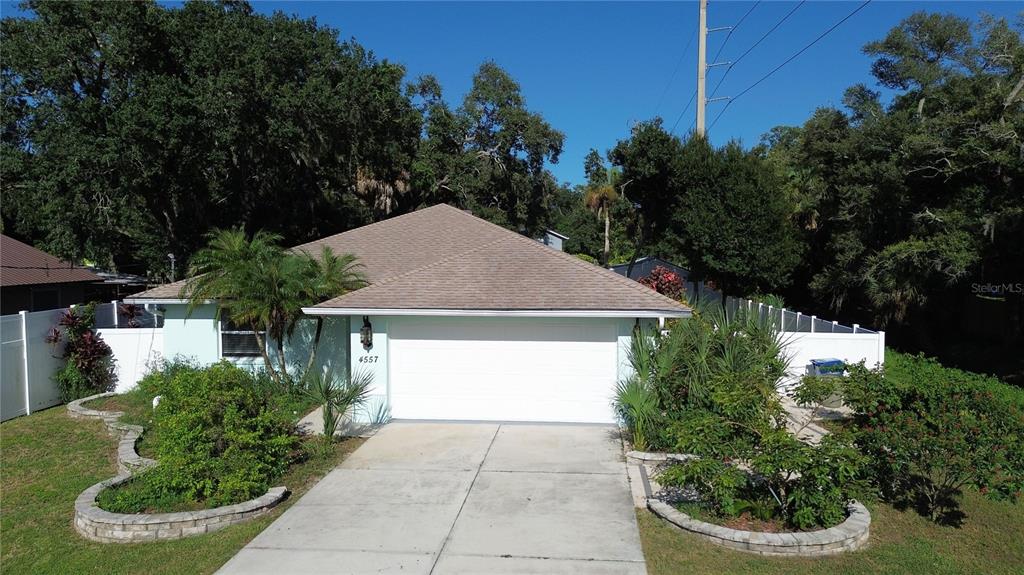 A single-story house with a white garage door, light blue siding, and a concrete driveway — 4557 WORCESTER ROAD, SARASOTA, FL