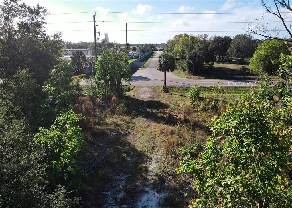 An elevated view of a vacant, wooded lot leading to a paved road — E VENICE AVENUE, VENICE, FL