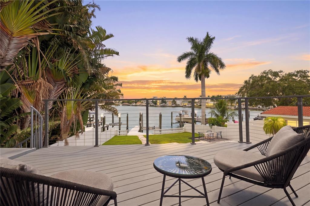 An aerial view of a waterfront house with a swimming pool, dock, and palm trees — 900 79TH STREET S, ST PETERSBURG, FL