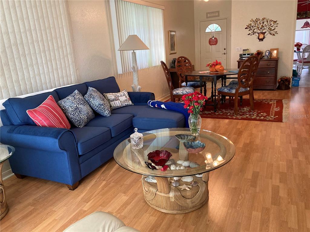 A living room features a blue sectional sofa, a glass coffee table, and a dining area — 1275 BERKSHIRE CIRCLE, VENICE, FL