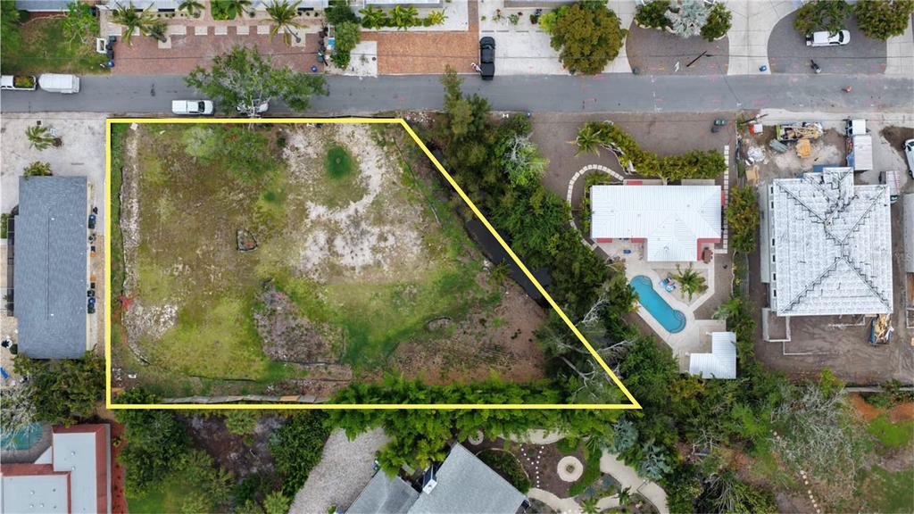 An aerial view shows a vacant, irregularly shaped lot outlined in yellow next to residential properties — 1122 CRESCENT STREET, SARASOTA, FL