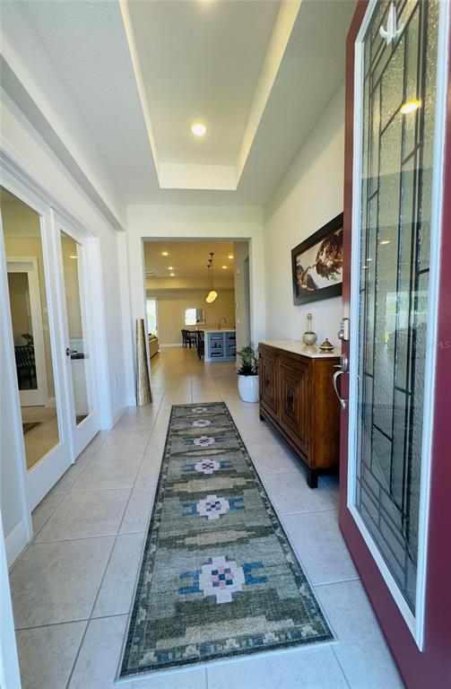 A tiled entryway leads into an open-concept living area with a runner rug and console table — 11753 JUNE BRIAR LOOP, SAN ANTONIO, FL