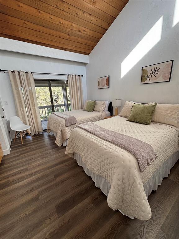 A bedroom features two beds, wood-paneled vaulted ceilings, and a sliding glass door to a deck — 507 MAPLE LEAF COURT UNIT N/A, HAINES CITY, FL