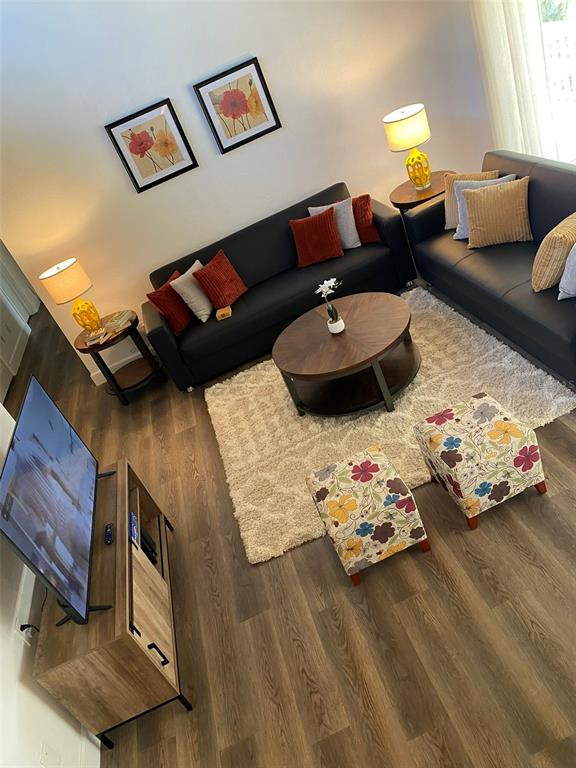 A living room features two dark sofas, a round coffee table, and two floral ottomans — 507 MAPLE LEAF COURT UNIT N/A, HAINES CITY, FL