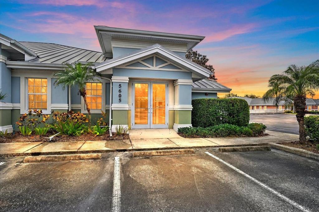 A single-story commercial building with a blue facade, glass double doors, and a parking lot — 5605 MARQUESAS CIRCLE UNIT 12C, SARASOTA, FL