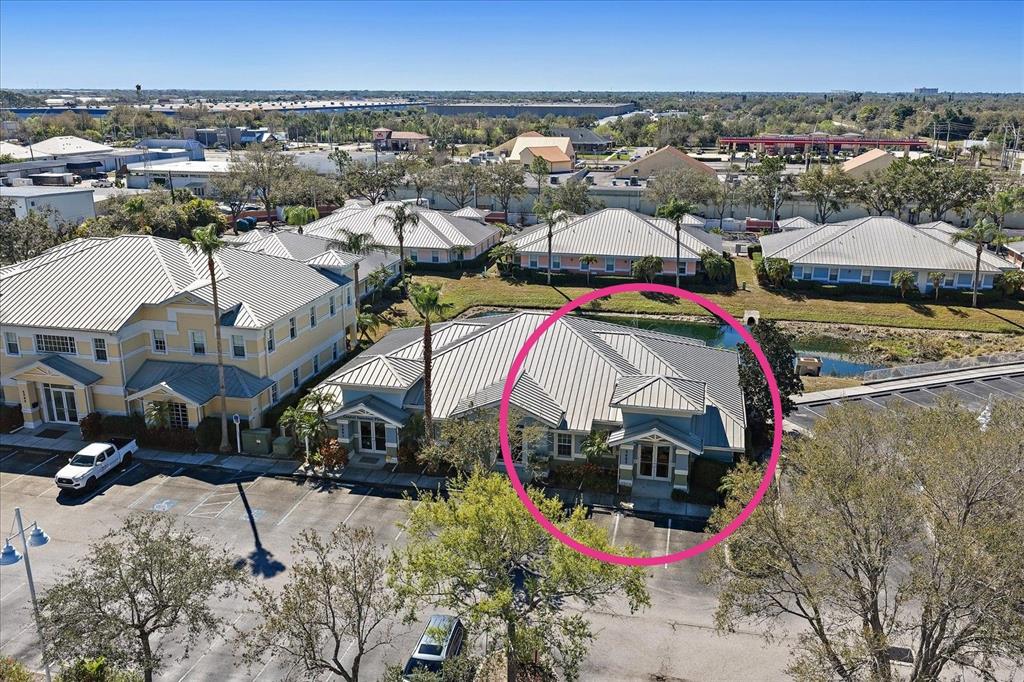 An aerial view shows a commercial building with a metal roof and parking lot — 5605 MARQUESAS CIRCLE UNIT 12C, SARASOTA, FL