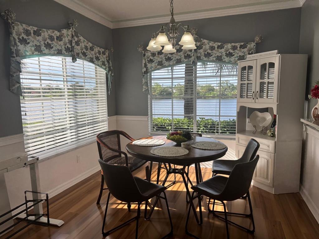 A living room features wood-look flooring, a blue sofa, and a semi-circular console table — 3603 45TH TERRACE W UNIT 101, BRADENTON, FL