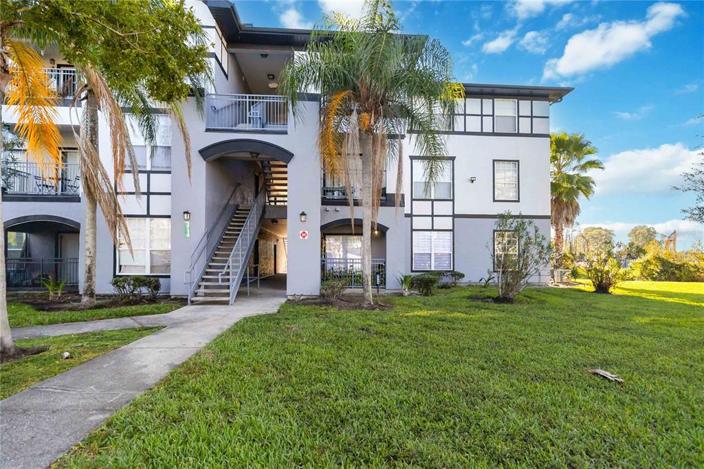 An empty room features wood-look flooring, white walls, a ceiling fan, and an entryway door — 3714 PALM DESERT LANE UNIT 5336, ORLANDO, FL