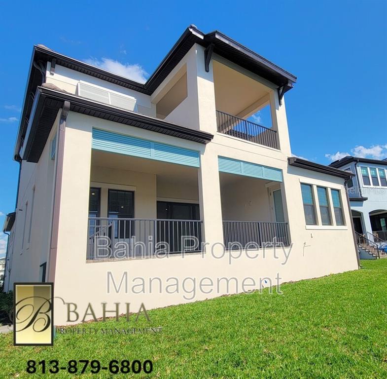 The exterior of a two-story house features a covered patio and a second-floor balcony — 1074 SEAGRAPE DRIVE, RUSKIN, FL