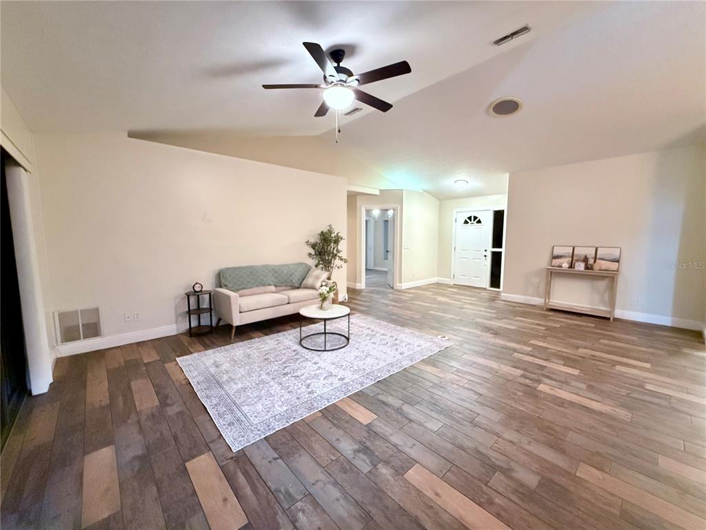 A living room features wood-look flooring, a ceiling fan, and a neutral color palette — 3530 W COGWOOD CIRCLE, BEVERLY HILLS, FL