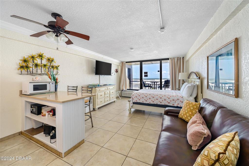 A balcony with patio furniture overlooks a grassy lawn and the ocean — 2301 S ATLANTIC AVENUE UNIT 236, DAYTONA BEACH, FL