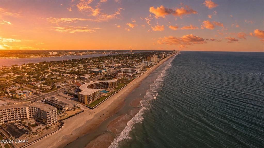 A bedroom with tile flooring, a queen bed, a dresser, and a balcony overlooking the ocean — 2301 S ATLANTIC AVENUE UNIT 236, DAYTONA BEACH, FL