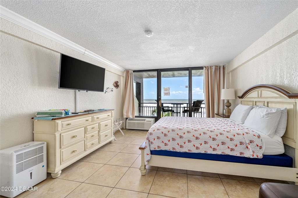 An aerial view shows a curved beachfront hotel with a large parking lot — 2301 S ATLANTIC AVENUE UNIT 236, DAYTONA BEACH, FL