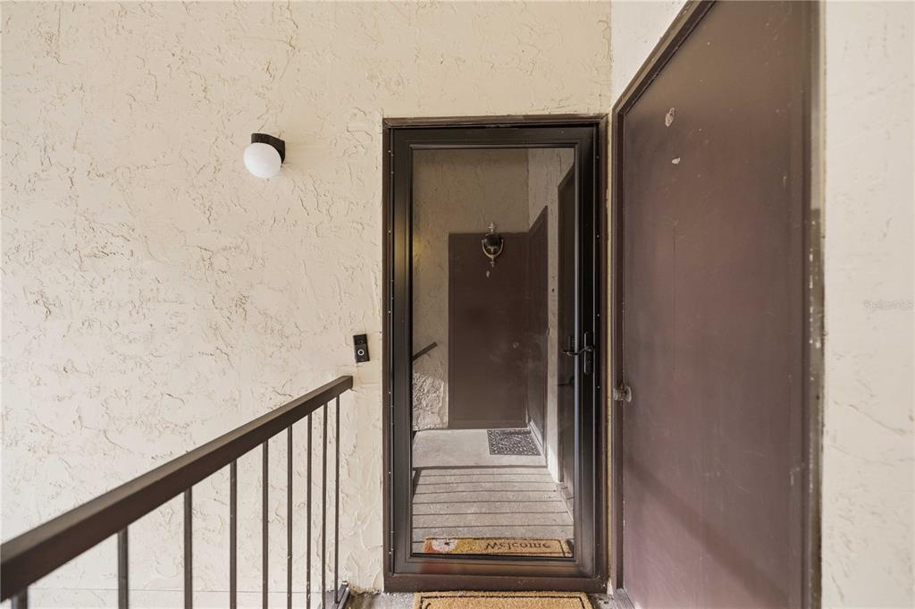 An exterior view of a residential entryway featuring a screen door and a solid door — 681 MIDWAY DRIVE UNIT B, OCALA, FL
