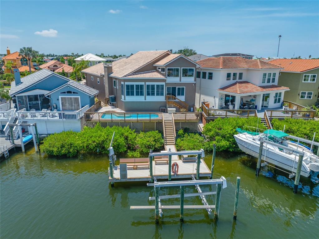 An aerial view of a waterfront house with a pool, deck, and private boat dock — 861 SYMPHONY ISLES BOULEVARD, APOLLO BEACH, FL