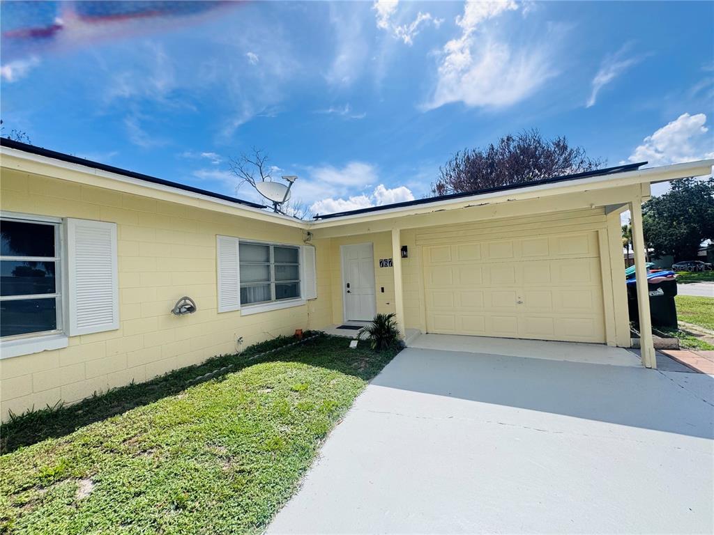 A yellow single-story house features a white front door, a garage, and a concrete driveway — 767 FORESTER AVENUE, ORLANDO, FL