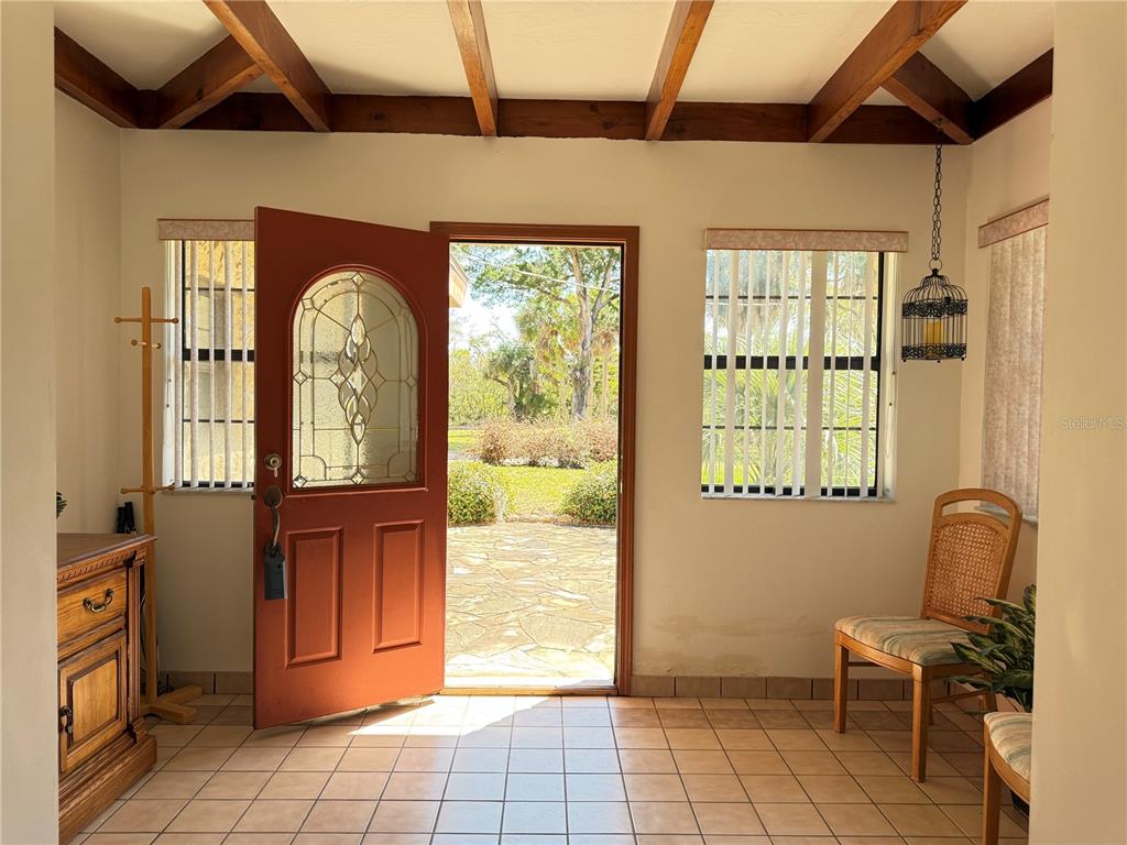 An entryway with tile floors, exposed wood ceiling beams, and a red front door — 508 S INDIAN RIVER ROAD, NEW SMYRNA BEACH, FL