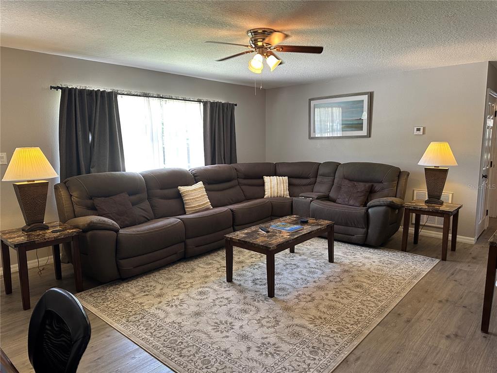 A living room features a large brown sectional sofa, a coffee table, and area rug — 3724 W SULLIVAN STREET, DUNNELLON, FL
