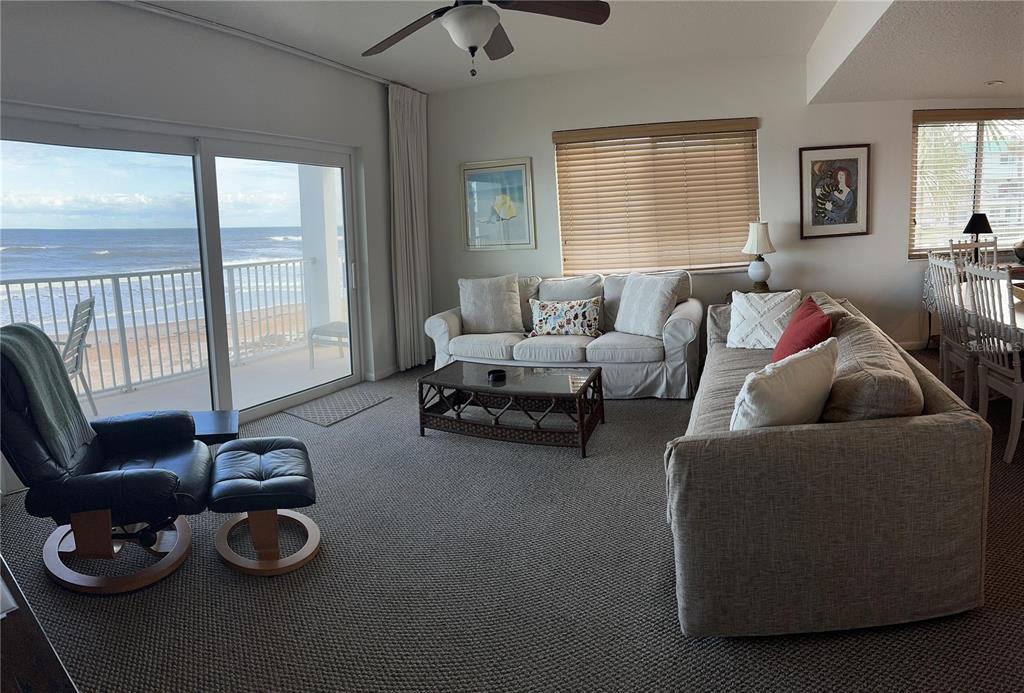 A living room features a sofa, a recliner, and a sliding door overlooking the ocean — 815 OCEAN SHORE BOULEVARD UNIT 13A, ORMOND BEACH, FL