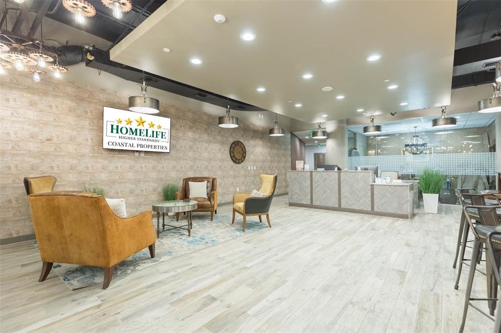 A modern office lobby features a reception desk, seating area, and wood-look tile flooring — 400 N ASHLEY DRIVE UNIT 2605, TAMPA, FL