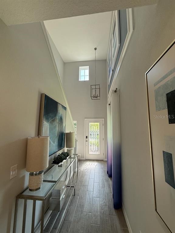A high-ceilinged entryway features a glass console table, wall art, and a front door — 309 PRESERVE POINTE BOULEVARD, DAVENPORT, FL