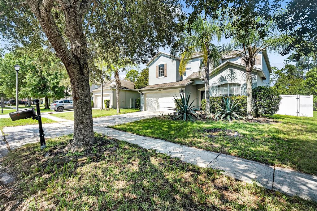 A dining area with a chandelier and a living room with white sofas and rugs — 5548 ANSLEY WAY, MOUNT DORA, FL