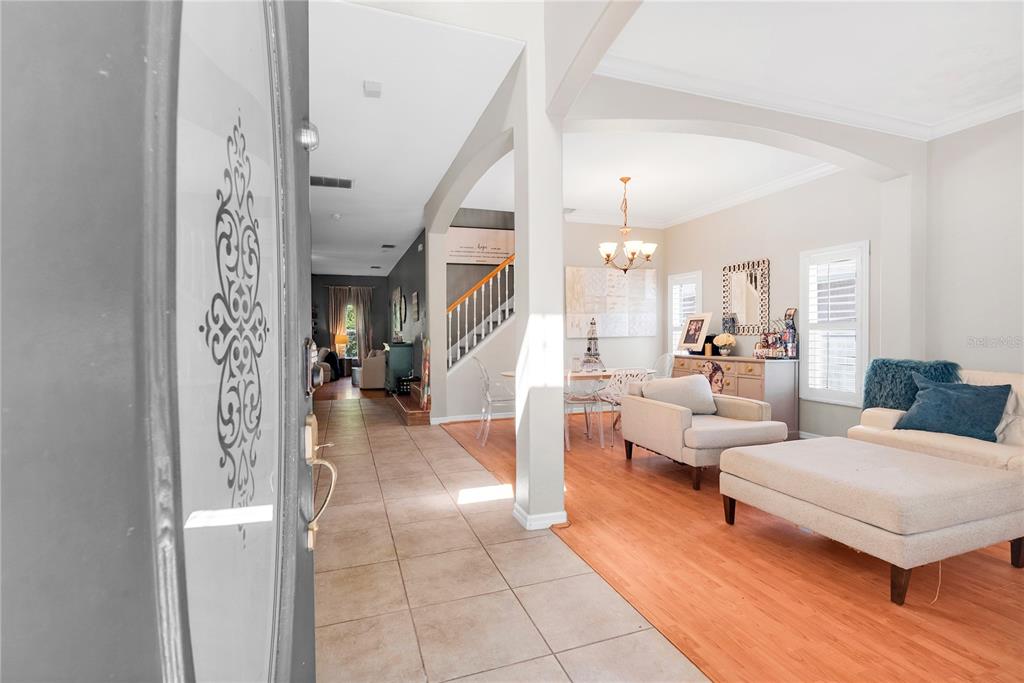 A kitchen with dark wood cabinets, black granite countertops, stainless steel appliances, and tile flooring — 5548 ANSLEY WAY, MOUNT DORA, FL