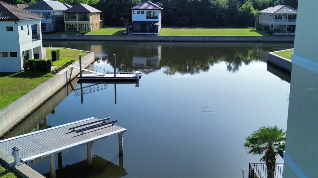 An elevated view shows a canal with two boat docks and several houses nearby — 243 YACHT HARBOR DRIVE, PALM COAST, FL