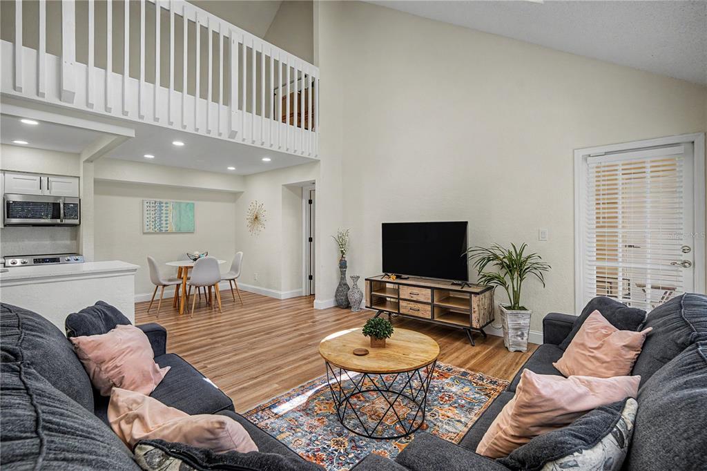 A black front door labeled 303 is at the top of an outdoor concrete staircase — 3266 HAVILAND COURT UNIT 303, PALM HARBOR, FL