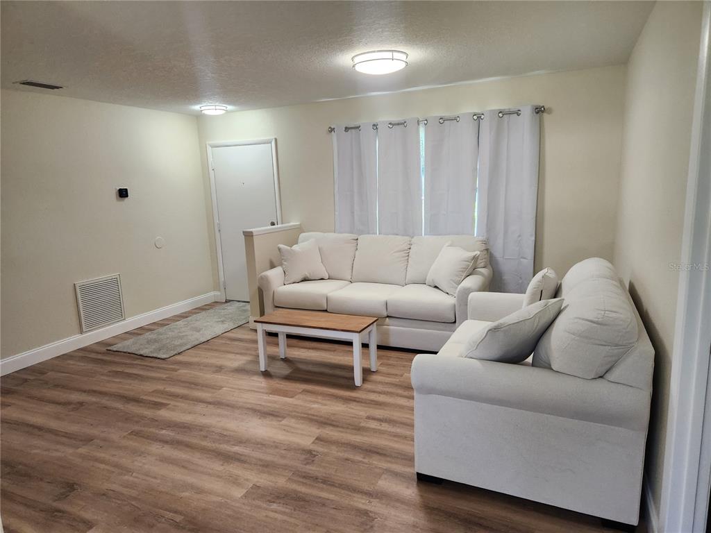 An empty bedroom features beige walls, gray carpeting, a ceiling light, and a window — 1652 SW HARLEM CIRCLE, ARCADIA, FL