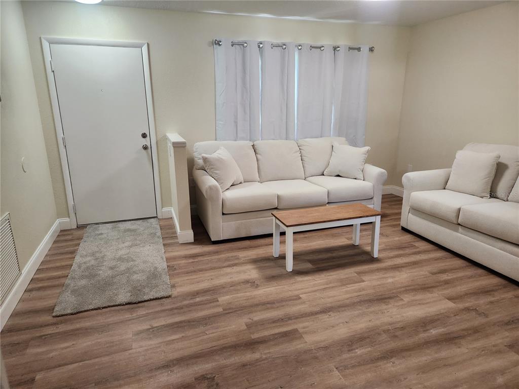 A small room with beige walls, gray carpeting, a ceiling light, and an open door — 1652 SW HARLEM CIRCLE, ARCADIA, FL