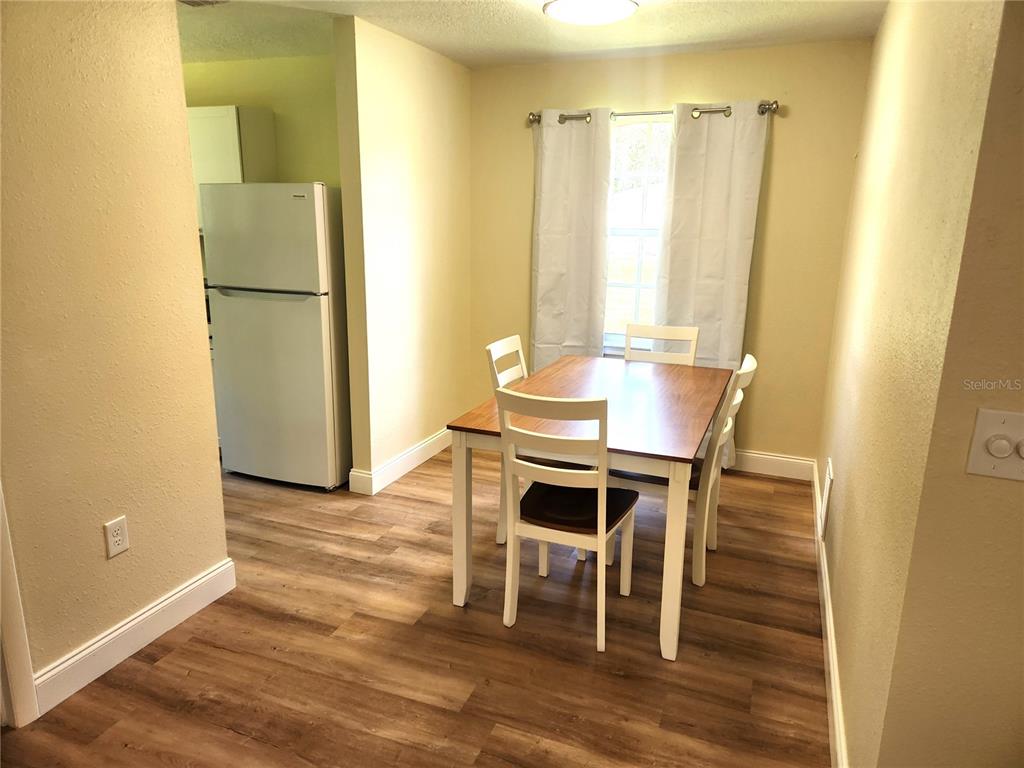 An interior view shows a room with light-colored walls, wood-look flooring, and a bathroom entrance — 1652 SW HARLEM CIRCLE, ARCADIA, FL
